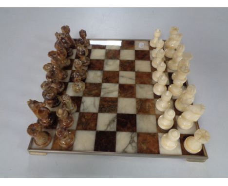 A metal and marble chess board with marble pieces.