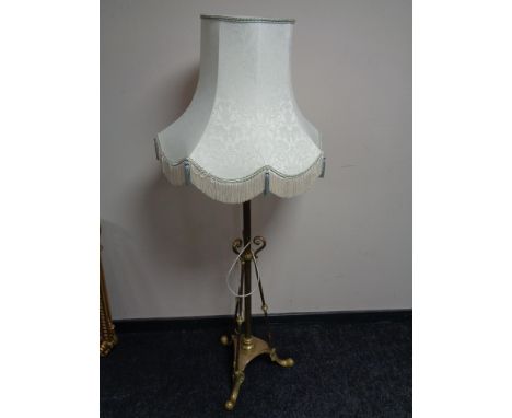 A brass Arts and Crafts rise and fall standard lamp with shade 