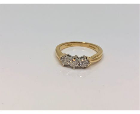 An 18ct gold three stone diamond ring, approximately 0.5 carat total, size L