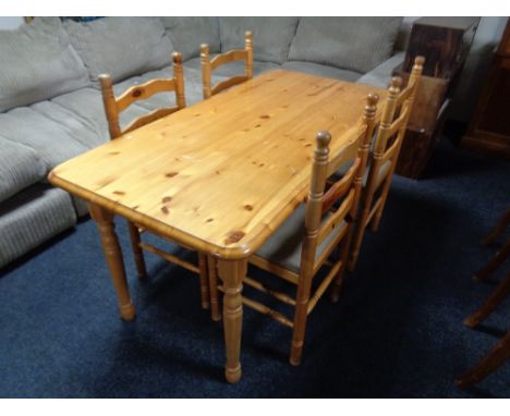 A pine rectangular kitchen table together with a set of four ladder backed chairs 