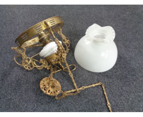 A Continental gilt metal hanging oil lamp with opaque glass reservoir (converted), with shade 