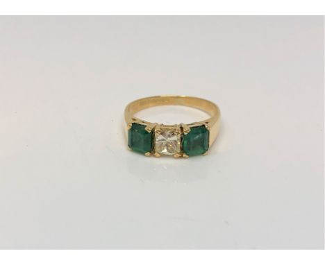 An 18ct gold emerald and diamond three stone ring, central diamond approximately 0.75 carat, size L CONDITION REPORT: The rin