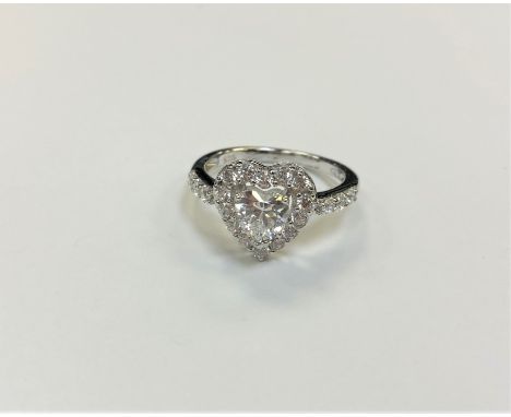 A white metal heart shaped dress ring, size O