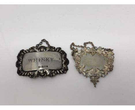 A silver Whisky decanter label and one other highly ornate silver label 