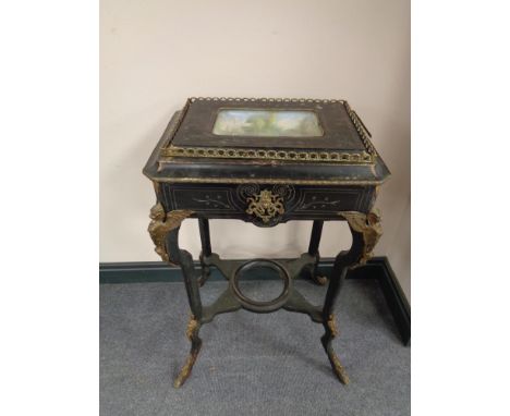 An unusual 19th century ebonised Empire style table with ormolu mounts and gallery, inset ceramic bowl top with plate glass 