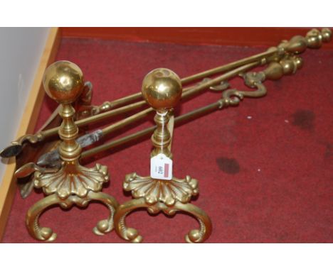 A pair of Georgian style brass firedogs and tools