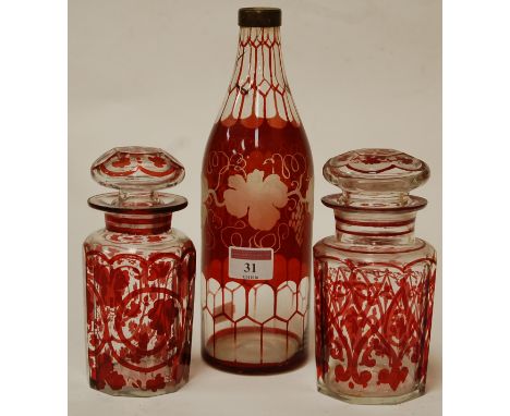 An early 20th century Bohemian style ruby overlaid glass bottle with etched ivy leaf decoration together with pair of similar