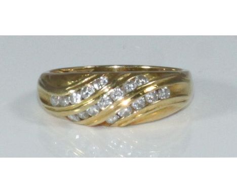 An 18ct yellow gold and diamond ring, the top of swirl design channel-set with seventeen small RBC diamonds, estimated total 