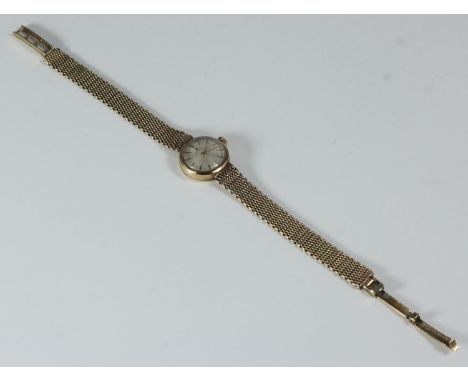 A ladies 9ct gold Tissot cocktail watch with circular case, plain champagne dial with batons denoting the hours, integral 9ct