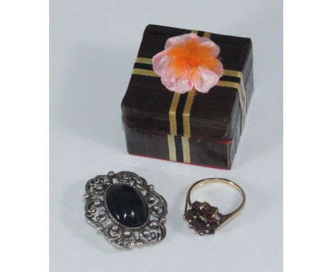 A 9ct gold and garnet tiered-cluster ring together with a costume jewellery brooch 