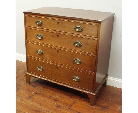 An oak chest of four long, graduated drawers, each with oval brass handles and escutcheons, raised on shaped bracket feet. 93