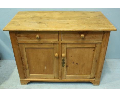 A pine cupboard with two short frieze drawers above two panelled cupboard doors enclosing shelf, raised on shaped bracket fee