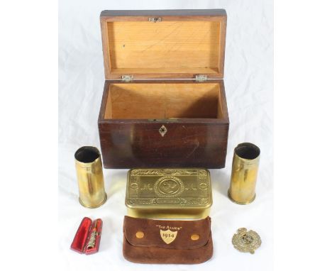 A small stained tea caddy, together with a WWI tin, two brass shell cases, a Royal Engineers badge and a silver and amber che