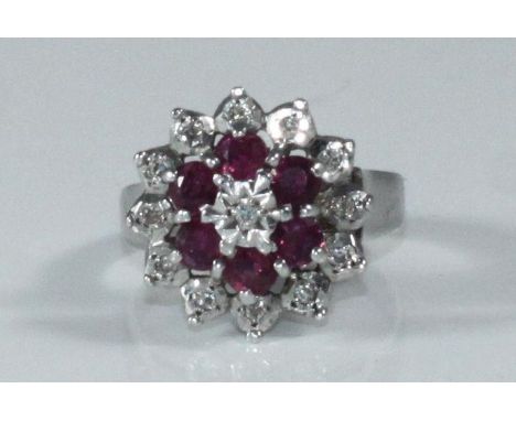 A 9ct white gold cluster ring set with thirteen small illusion set diamonds and six ruby coloured stones, gross weight approx