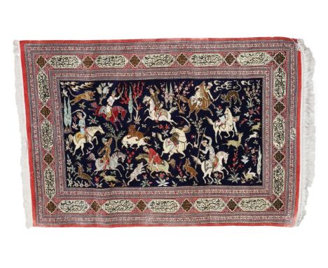 Ghom Silk Rug Central Iran, late 20th century The indigo field depicting hunting scenes enclosed by salmon pink borders withi