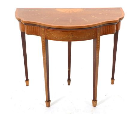 A Mahogany, Satinwood and Marquetry Inlaid Foldover Card Table, of serpentine shaped form, the top inlaid with flowerbells an