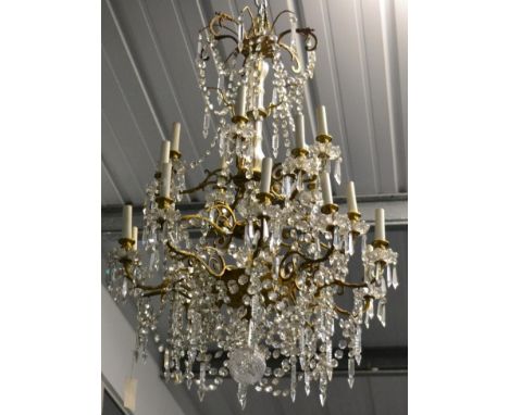 A Gilt Metal and Cut Glass Twenty Light Chandelier, late 19th century, with campana sconces, circular drip pans and scroll br