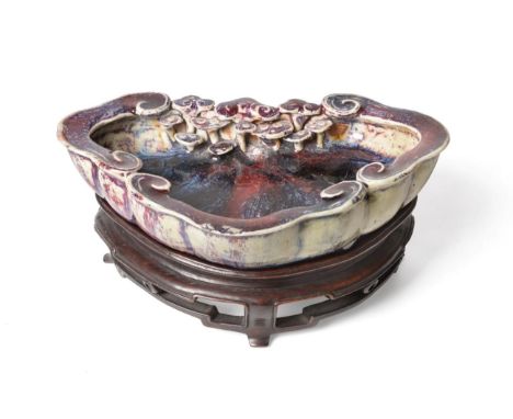 A Chinese Sang de Boeuf Glazed Brush Washer, probably Yongzheng period, of cloud scroll form moulded with further cloud scrol