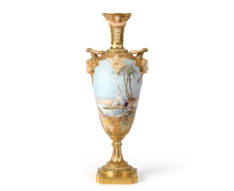 A Royal Worcester Porcelain Urn Shaped Vase, by Walter Powell, 1910, with mask handles, painted with storks wading in a shall