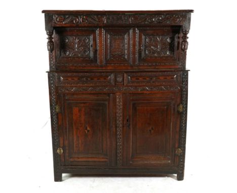 A Joined Oak Press Cupboard, the later boarded top above a carved frieze bearing initials TCM and dated 1708 flanked by carve