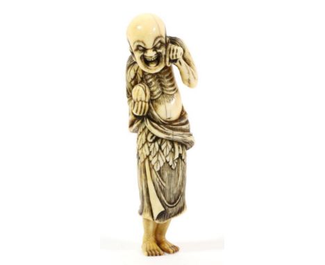 A Japanese Ivory Netsuke, Edo period, modelled as a Sennin wearing a fur coat holding a clam, 9.5cm high