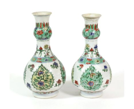 A Pair of Chinese Porcelain Bottle Vases, Kangxi, with garlic necks, painted in famille verte enamels with flowers in lappet 