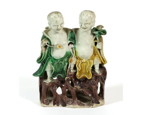 A Chinese Porcelain Figure Group, Kangxi, as two children sitting on a rocky outcrop decorated in famille verte enamels, 14.5