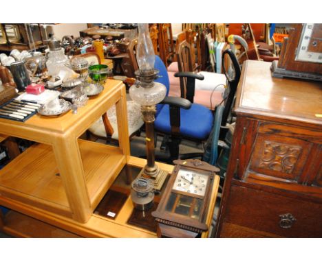 An oak cased two hole wall clock, a brass Corinthian column oil lamp with cut class font and an oil lamp part