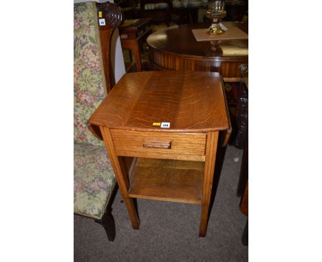 An oak drop leaf occasional table, fitted a frieze drawer and shelf under, raised on square legs.