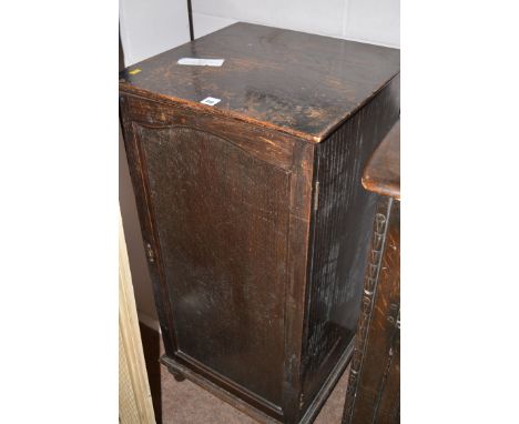 A dark stained oak pedestal cabinet with panel door.