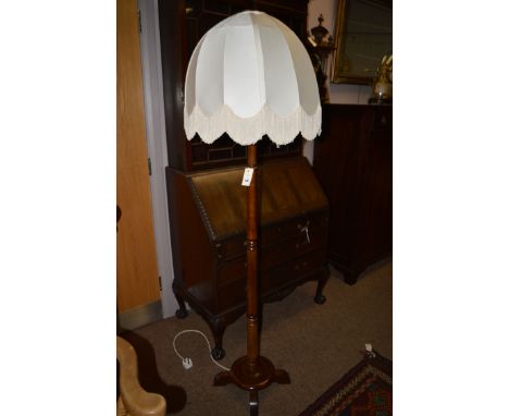 A beech wood standard lamp with cream silk shade.