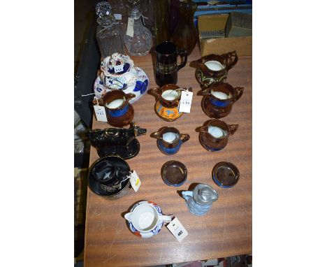 A collection of copper lustre ware; a blue ceramic jug with raised floral decoration and hinged pewter lid; a cow creamer; et