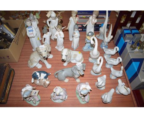 A collection of twenty six Nao figures; swans and dogs.