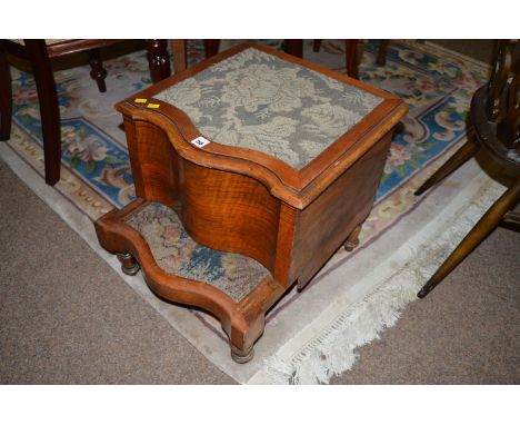 A Victorian walnut bed step commode, the serpentine carpet mounted top opening to reveal ceramic liner, with under step below