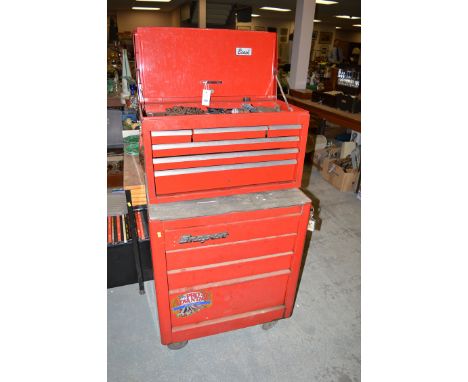 A red painted metal tool storage cabinet, with an assortment of shallow drawers and hinged cover, and a label inscribed 'Beac