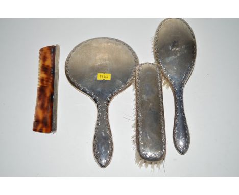 A silver backed dressing table set, to include; hand mirror, hand brush, clothes brush and associated comb.