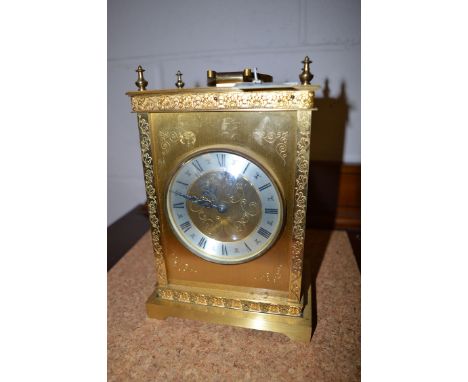 A brass cased mantel clock by Elliott, London, with leaf decoration to border.