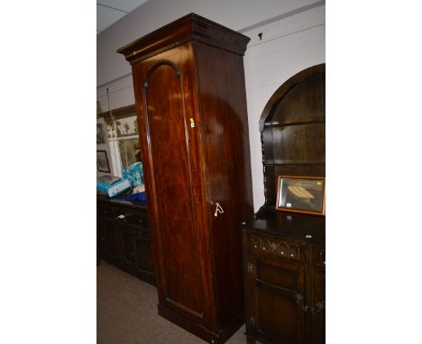 A Victorian mahogany hall wardrobe, the flared top above panel door enclosing shelves and underlying drawer.