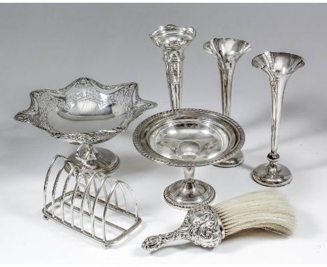 A George V silver rectangular six division toast rack of pointed arch form, with conforming loop handle and on panel feet, 5.