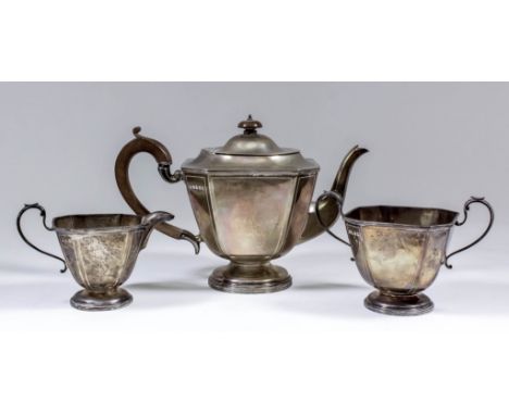 A George V silver octagonal three piece tea service of panelled form, with C-scroll handles and on circular moulded footrim, 