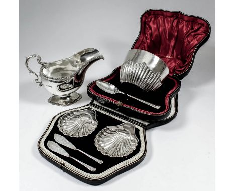 An Edward VII silver oval sauce boat with gadroon mounts, leaf capped scroll handle, on shaped footrim, 5ins high, by James R