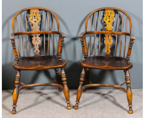 A pair of 20th Century ash and elm seated "Nottinghamshire" Windsor stick back armchairs, the two tier backs with fretted and