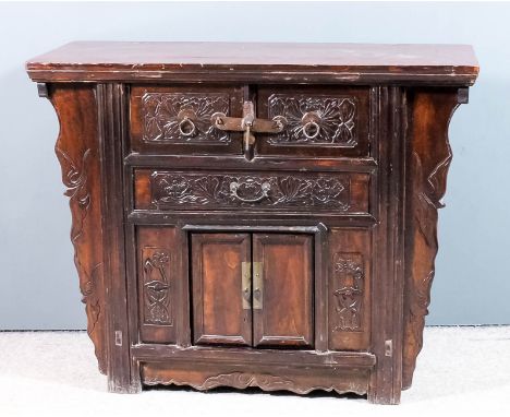 A Chinese stained wood dwarf cabinet with flush panel to top, the front carved with leaf ornament, fitted two deep drawers, o