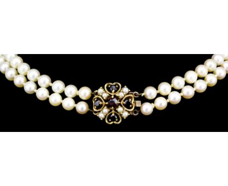 A modern twin strand of graduated cultured pearls ranging from 5mm to 8mm, with 9ct gold seed pearl and garnet set clasp, 410