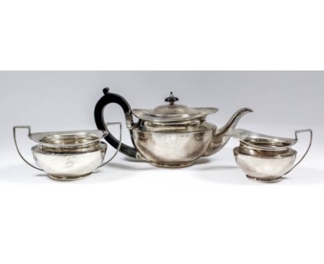 An Edward VII silver circular three piece tea service of bulbous squat form, comprising - teapot with ebonised C-scroll handl