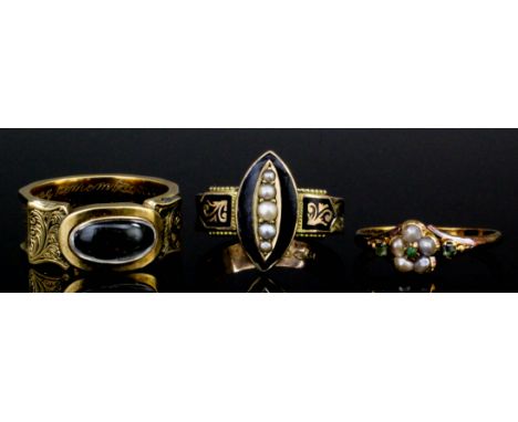 A Victorian gold coloured metal mourning ring, the face set with an oval cabochon cut rock crystal to engraved borders and wi