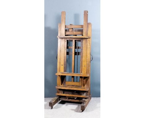 A large Winsor and Newton oak "Improved Studio Easel" sold by All Artists Colourmen & Co, with shelves and adjustable height 