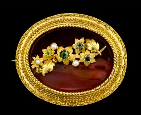 A Victorian gold coloured metal mounted carnelian, garnet and seed pearl set oval pattern brooch, the central oval panel set 