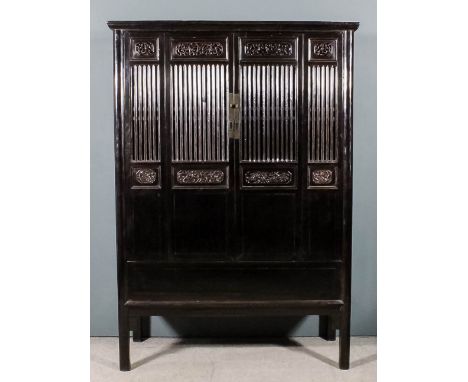 A Chinese stained wood and panelled cabinet, the upper part with moulded cornice, fitted one shelf and two drawers, enclosed 