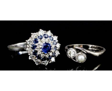 A modern 18k white mounted sapphire and diamond flower head pattern ring, set to the centre with a circular cut sapphire of a